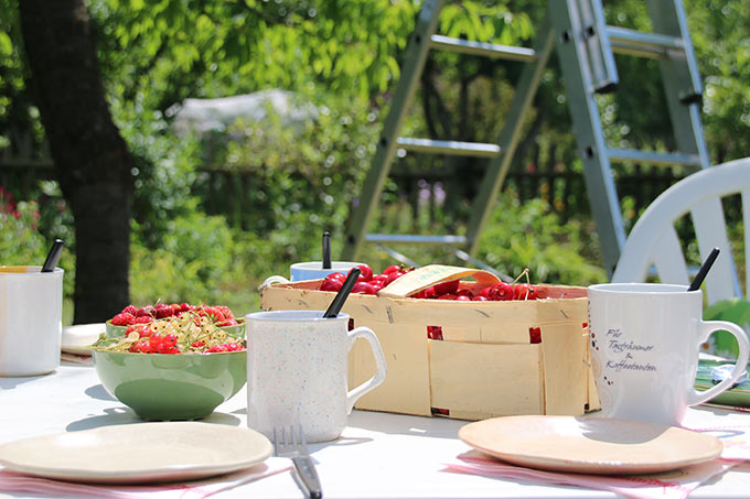 Gartentisch mit Tassen und Kuchen